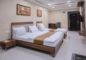 a bedroom with two beds in a room at StayGuru Park View Residency in Bhuj