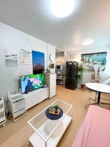 a living room with a tv and a table at Bangkok Prime Location Residence in Makkasan