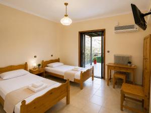 a bedroom with two beds and a balcony at Panorama Plataria Ionio Studios&Apartments in Plataria