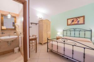 a bedroom with a bed and a sink and a bathroom at Sole del Mediterraneo in Otranto