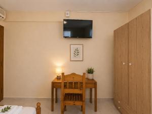 a room with a table and a tv on the wall at Panorama Plataria Ionio Studios&Apartments in Plataria