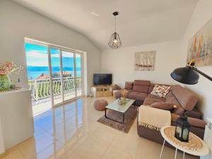 a living room with a couch and a view of the ocean at Apartman Ruza 2 in Opric