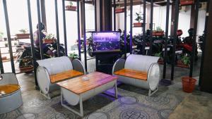 a room with two chairs and a table and a tv at Artemis Hotel Bekasi in Cikunir Satu +12 photos