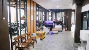 a room with chairs and tables and motorcycles at Artemis Hotel Bekasi in Cikunir Satu