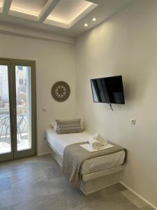 a bedroom with a bed and a tv on the wall at Ione Inn in Naxos Chora