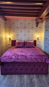 a bedroom with a purple bed with purple sheets at De Gouden Cruytbusse in Middelburg