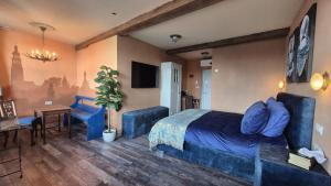 a bedroom with a blue bed and a table and chair at De Gouden Cruytbusse in Middelburg