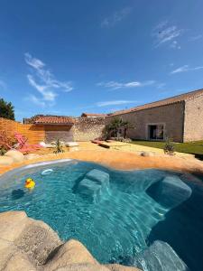 a swimming pool in front of a house at Le Logis de la Gabirotte in Nieulle-sur-Seudre