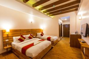 a bedroom with two beds and a flat screen tv at DANFÉ Lodge Halesi in Lamidanda