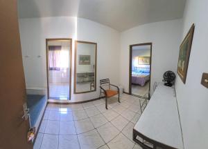 a living room with a table and a room with a bed at Pousada Catuaí in Siqueira Campos