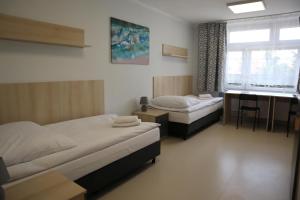 a bedroom with two beds and a desk and a window at Dom Sportowca in Krosno