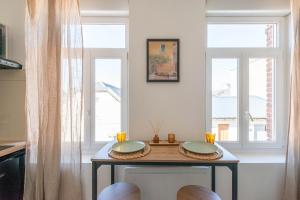 a table in a kitchen with two windows at Casa 37 in Saint-Quentin