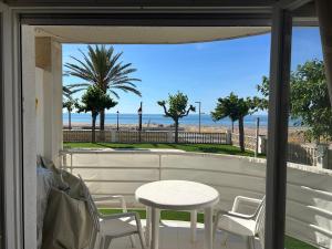 a table and chairs on a balcony with a view of the beach at Right on the beach in Cubelles