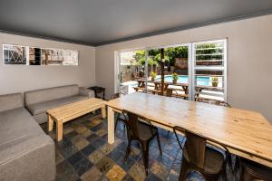 a living room with a wooden table and a couch at Lungile Backpackers in Gqeberha