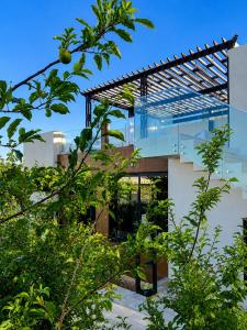 a house with a glass facade with trees at Zahret Al Roman in Sayq