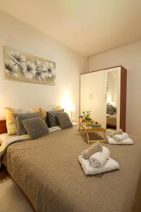 a bedroom with a large bed with towels on it at Apartman Ruza 2 in Opric
