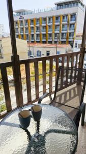 a glass table with two cups on a balcony at SKY Way City Apartment, 150m from Chabad Lubavitch in Larnaca