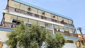 an apartment building with balconies and a tree at SKY Way City Apartment, 150m from Chabad Lubavitch in Larnaca