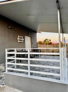 a porch with a white fence and a table at Villa Alonia House in Kallithéa