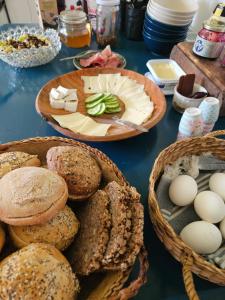 a table with baskets of bread and eggs on it at Benneweis in Brædstrup