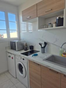 a kitchen with a washing machine and a sink at L'Escale Sablaise in Les Sables-d'Olonne