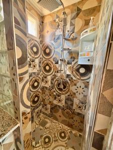 a bathroom with a shower with a tiled floor at LOUIZA HOUSE, vue imprenable entre lac et désert in Lalla Takerkoust