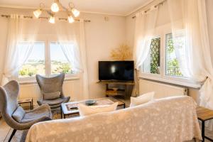 a living room with a couch and chairs and windows at Hill View 4 in Alexandroupoli