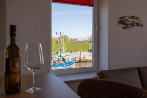 a bottle of wine sitting on a table with a wine glass at Heimathafen über dem Hafen - Pub in Pellworm