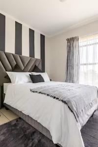 a bedroom with a large white bed with black and white stripes at Above Cozy Corner Amsterdam in Northriding +19 photos