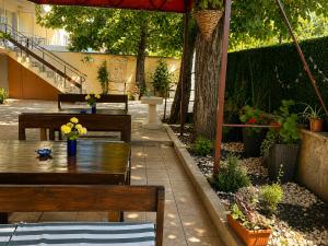 a patio with two benches and a table with flowers at Family Hotel Yulian in Kranevo +23 photos