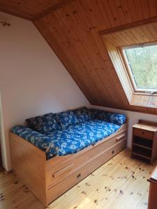 a bed in a room with a window at Wiesiówka nad Wkrą in Goławice