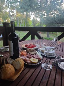 a table with plates of food and a bottle of wine at Wiesiówka nad Wkrą in Goławice