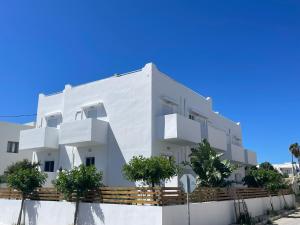 a white building with trees in front of it at MyLiving in Kardamaina