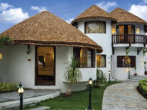 a large house with a thatched roof at Treat Resort Rajkot in Rajkot