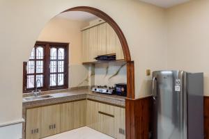 a kitchen with a stainless steel refrigerator and an archway at Comfort Apartment in Bālāju