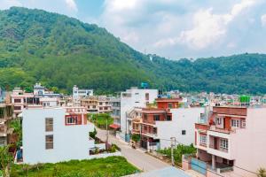 a city with buildings and mountains in the background at Comfort Apartment in Bālāju