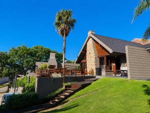a palm tree in front of a house at Lungile Backpackers in Gqeberha
