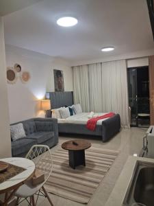 a living room with a couch and a bed at The Loftel in Ruaka +26 photos