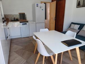 a kitchen with a white table and white chairs at JOLI 2 PIECES SERRIERA in Serriera +1 photo
