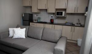 a living room with a couch and a kitchen at Tubalala Properties in Rustenburg