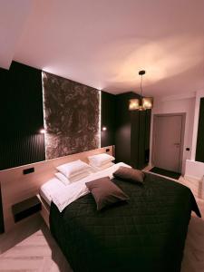 a bedroom with a large green bed with pillows at Shiro Nord in Predeal