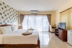 a bedroom with a large bed and a television at Alisa Krabi Hotel-SHA Plus in Krabi