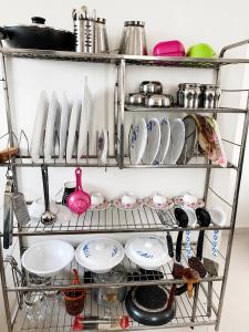 a shelf with dishes and utensils in a kitchen at Sai Mahima Stays in Shirdi +26 photos