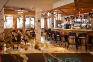 a bar with a bunch of bar stools in a room at Heart Hotel Sylvia in Ischgl