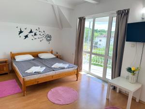 a bedroom with a bed and a large window at Guest House Orfey in Kranevo