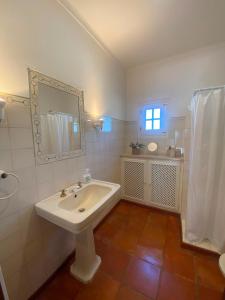 a white bathroom with a sink and a mirror at Casa Merino in Évora