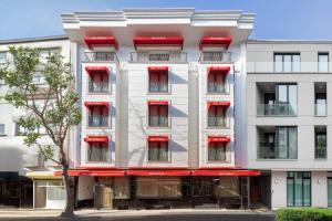 an apartment building with red windows and a tree at De Bonte in Istanbul