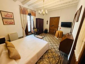 a bedroom with a bed and a television in it at Benafique La casa del Ciprés - refugio de calma en la Sierra de Huelva in Cortegana