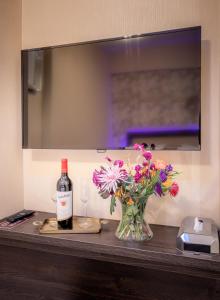 a bottle of wine and a vase of flowers on a table at Hotel Oscar in Amsterdam +31 photos
