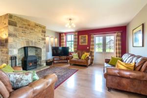 a living room with leather furniture and a stone fireplace at 3 Bed in Consett oc-29408 in Lanchester